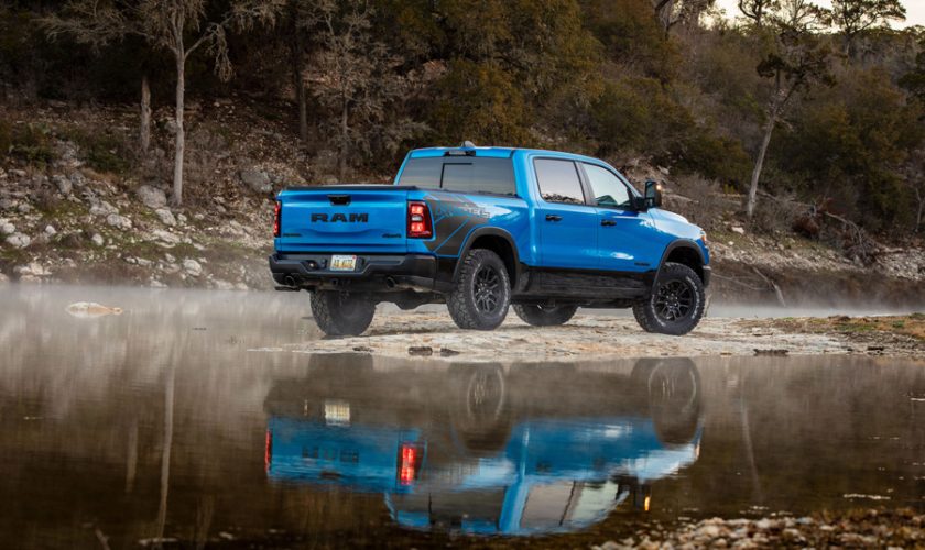 Blue 2025 model RAM Rebel reflected in a beautiful lake