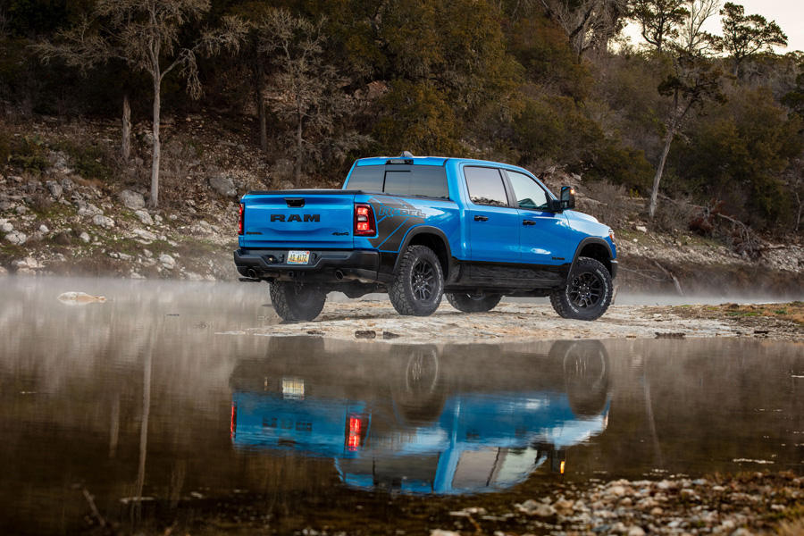 Blue 2025 model RAM Rebel reflected in a beautiful lake